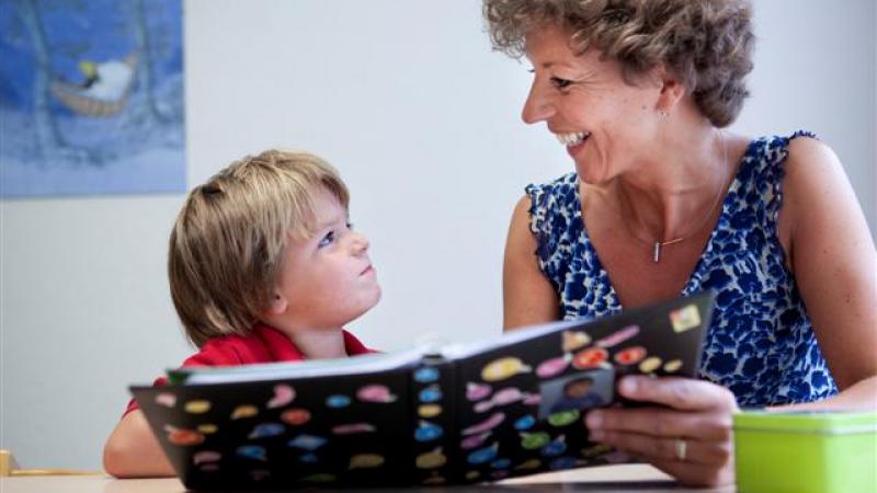 Ambulante begeleidster leest samen met een jongetje
