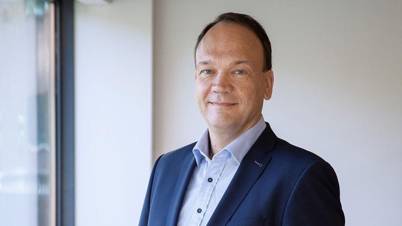 Foto Remmelt Vetkamp. Man, kort donker haar, draagt een blauw kostuum