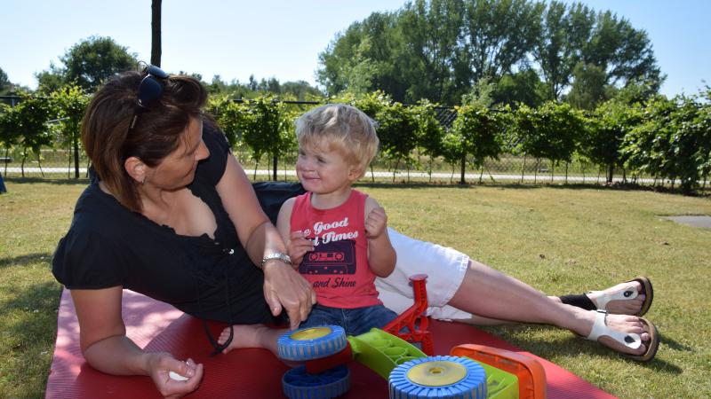 Vrouw en kind samen op speelkleed