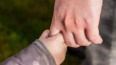 Moeder en kind Kind houdt vinger van moeder vast