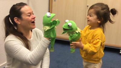 Mila en haar moeder spelen met Kermit handpoppen Mila bij de Communicatie Plus groep