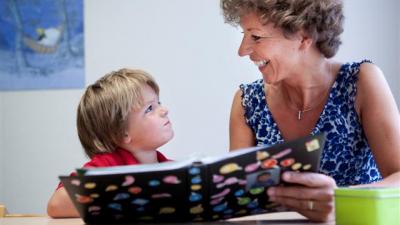 Ambulante begeleidster leest samen met een jongetje Ambulante begeleidster leest samen met een jongetje
