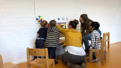 Leren communiceren bij de vroegbehandeling Kinderen en medewerkers doen een spelletje
