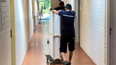 Kentalis de Taalster nu op 1 locatie Afbeelding: Jongen loopt in de gang met een kar met verhuisdozen
